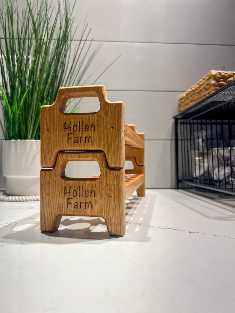 Peut inclure: Un &eacute;tag&egrave;re en bois &agrave; deux niveaux avec les mots "Hollen Farm" grav&eacute;s sur chaque niveau. L'&eacute;tag&egrave;re est en bois brun clair et a un aspect rustique.