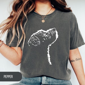 May include: A dark gray t-shirt with a white silhouette of a dog's head looking up. The text "PEPPER" is visible at the bottom of the image.