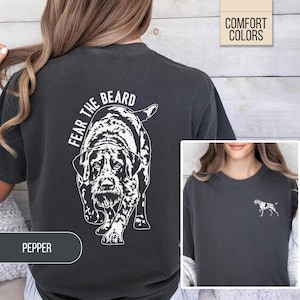 May include: Dark gray t-shirt with a white graphic of a dog and the text "FEAR THE BEARD". The shirt also has a small dog graphic on the front. The shirt is labeled "PEPPER" and "COMFORT COLORS".