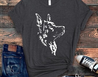 May include: A dark gray t-shirt with a white silhouette of a German Shepherd dog's head facing right.