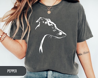 May include: Dark grey t-shirt featuring a white line drawing of a dog's head in profile. The word "PEPPER" is displayed in a dark grey rectangle at the bottom. The shirt has short sleeves and a crew neck.