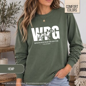 May include: A long-sleeve olive green sweatshirt featuring the white text WPG and a graphic of a Wirehaired Pointing Griffon dog. Below the dog, the text reads WIREHAIRED POINTING GRIFFON FIELD DOG. A small label in the corner says COMFORT COLORS.