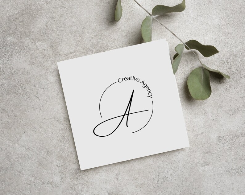 May include: A white card with a black and white logo that says "Creative Agency" in a circle around a stylized letter "A".