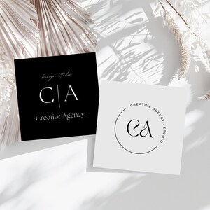 May include: Two business cards with a minimalist design. The first card is black with white text that reads "Design Studio CA Creative Agency". The second card is white with a black circle containing the letters "CA" and the text "Creative Agency Studio".
