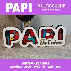 Op de afbeelding: Een houten bord met de tekst "PAPI" in witte letters met rode en blauwe accenten, en de zin "Je t'aime". Het bord bevat gereedschap in de letters. De woorden "MULTICOUCHE DIGITAL DOWNLOAD" staan bovenaan.