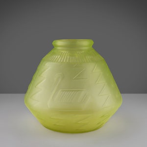 May include: A yellow glass vase with a geometric pattern. The vase has a wide base and a narrow neck.