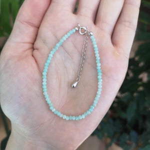 Può includere: Un braccialetto delicato realizzato con perline di pietre preziose blu chiaro e una chiusura argentata.