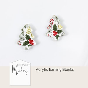 Pode incluir: Duas bases de brincos de acrílico em forma de árvore de Natal. As árvores são brancas com um padrão de folhas verdes de azevinho, bagas vermelhas e detalhes dourados. O texto "Midwest Makery" e "Acrylic Earring Blanks" também são visíveis.