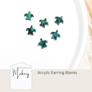 May include: Six teal green acrylic turtle earring blanks on a white surface. The text "Midwest Makery" and "Acrylic Earring Blanks" is visible in the image.