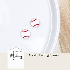 May include: Two white acrylic earring blanks shaped like baseballs with red stitching. The blanks are on a white plate. The text "Midwest Makery Acrylic Earring Blanks" is below the plate.