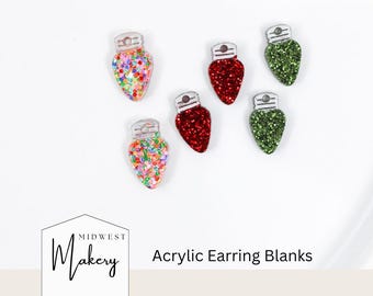 May include: Acrylic earring blanks in the shape of Christmas lights. The blanks are in various colors, including red, green, and a multicolored confetti design. The text "Midwest Makery" and "Acrylic Earring Blanks" are also visible.