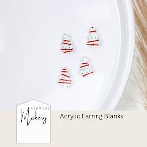 K&ouml;nnte beinhalten: Vier wei&szlig;e Acryl-Ohrringrohlinge in Form von Weihnachtsb&auml;umen mit roten und gr&uuml;nen Streifen und gr&uuml;nen Punkten. Die Rohlinge befinden sich auf einer wei&szlig;en Oberfl&auml;che.  Midwest Makery Acrylic Earring Blanks.