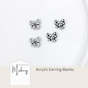 May include: Four black and white acrylic earring blanks in a bow shape. The bows are on a white background. The text "Acrylic Earring Blanks" is in the image.