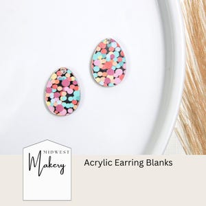 May include: Two colorful acrylic earring blanks in a teardrop shape with a confetti pattern. The blanks are on a white surface. Midwest Makery Acrylic Earring Blanks.