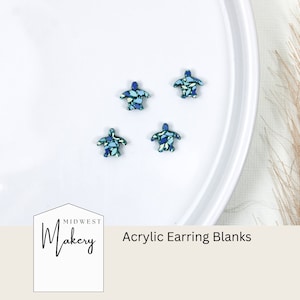 May include: Four blue and green acrylic turtle earring blanks on a white surface. The text "Midwest Makery" and "Acrylic Earring Blanks" is visible below the turtles.