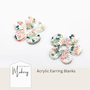 May include: Two floral acrylic earring blanks. The blanks are shaped like a flower with five petals and a hole in the centre. The floral pattern is pink, green and white.
