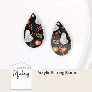 May include: Two teardrop-shaped acrylic earring blanks. Each blank features a black background with a pattern of white ghosts, orange pumpkins, and autumn leaves. The text "Acrylic Earring Blanks" is visible.