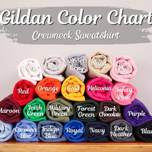 May include: Gildan Color Chart for Crewneck Sweatshirts. The chart shows a variety of colors, including maroon, light blue, Carolina blue, indigo blue, royal blue, navy, dark heather, black, purple, dark chocolate, forest green, military green, Irish green, orange, red, gold, heliconia, safety pink, light pink, sand, sport gray, ash, and white.