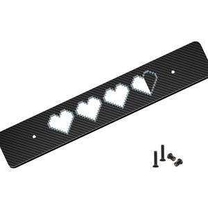 May include: A black carbon fiber plate with five white pixelated hearts. The plate has two small holes for mounting. The plate is included with four small black screws.