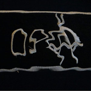 Könnte beinhalten: Schwarzer rechteckiger Aufnäher mit weiß gesticktem Text und einer stilisierten Figur. Der Text lautet "OP" mit einem abstrakten Design. Der Aufnäher hat einen weißen Rand.