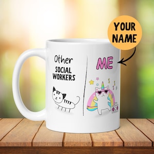 Könnte beinhalten: Eine weiße Keramiktasse mit einer Schwarzweißillustration einer Katze auf der linken Seite und dem Text "Other Social Workers". Auf der rechten Seite befindet sich eine bunte Illustration einer Katze mit einem Einhornhorn, Sonnenbrille und einem Regenbogen dahinter. Der Text "ME" befindet sich über der Katze und der Text "YOUR NAME" befindet sich in einem gelben Kreis über der Tasse.