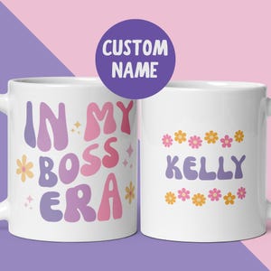 May include: White ceramic mug with a black handle, featuring the text "But First, Coffee" in black. The mug is displayed against a blurred backdrop, implying a comfortable environment.