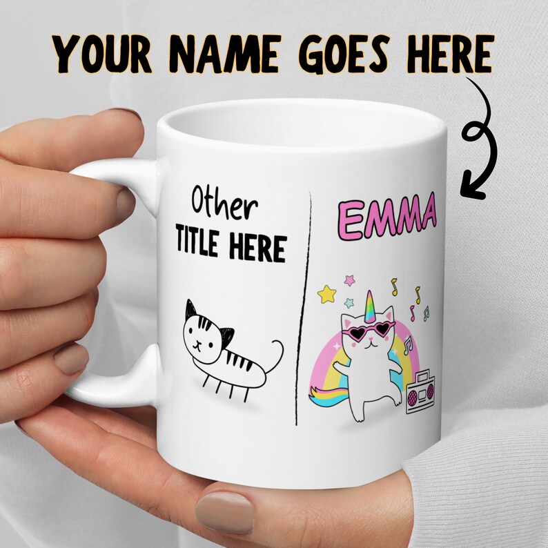 May include: White ceramic mug with a black and white drawing of a cat on one side and a colorful illustration of a cat with a unicorn horn and sunglasses on the other side. The text "Other Title Here" is on the left side and "Emma" is on the right side.