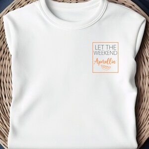 Könnte beinhalten: Weißes T-Shirt mit dem Text "Let the weekend Aperollin'" in einem Kasten mit einer Orangenscheibengrafik.