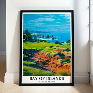 May include: A vintage travel poster design featuring a scenic view of a golf course with green grass and red sand dunes, overlooking a blue ocean with rocky cliffs and a cloudy sky. The poster has the text "Bay of Islands, New Zealand".