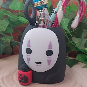 Könnte beinhalten: Schwarzer No Face-Charakter-Bleistifthalter mit einer roten Laterne und einem Zuckerrohr, einem rosa-blauen Zauberstab und mehreren Stiften im Inneren.
