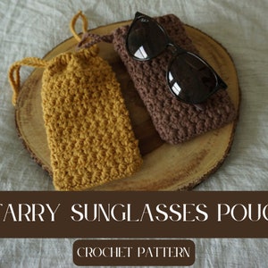 Może przedstawiać: Dwa dzianinowe etui na okulary przeciwsłoneczne, jedno brązowe, a drugie musztardowe, na drewnianej powierzchni. Tekst "Starry Sunglasses Pouch Crochet Pattern" znajduje się pod etui.