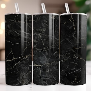 May include: Three stainless steel tumblers with clear straws. The tumblers have a black marble design with white and gold veining. The tumblers are cylindrical and have a silver rim and lid.