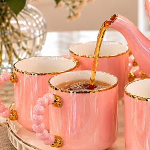 Juego de té de cerámica con diseño floral, bandeja giratoria, tetera y tazas con diseño de rosas rosas.