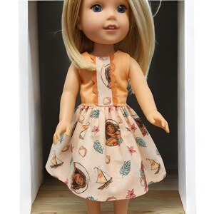 Puede incluir: Una mu&ntilde;eca con un vestido color melocot&oacute;n con estampado floral. El vestido presenta un corpi&ntilde;o sin mangas y una falda acampanada. La falda est&aacute; adornada con ilustraciones de un personaje, veleros y hojas tropicales. La mu&ntilde;eca tiene cabello rubio y ojos azules.