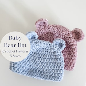 Puede incluir: Dos gorros de bebé de oso tejidos a crochet, uno en azul claro y otro en rosa. Los gorros tienen orejas de oso y están hechos con un hilo suave y esponjoso. El texto "Baby Bear Hat Crochet Pattern 5 Sizes" es visible en un círculo blanco.