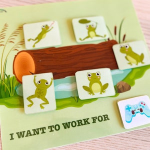 May include: A light green game board with the text "I WANT TO WORK FOR". The board features a log, water, and several cartoon frogs. One tile shows a blue and white game controller.