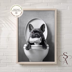 May include: A black and white photo of a French bulldog sitting on a toilet with a roll of toilet paper in its mouth.