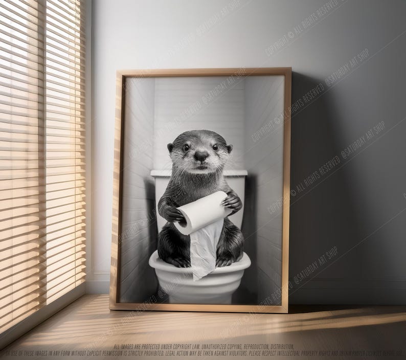 May include: A black and white photo of an otter sitting on a toilet holding a roll of toilet paper. The otter is looking directly at the camera.