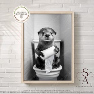 May include: A black and white photo of an otter sitting on a toilet holding a roll of toilet paper. The otter is looking at the camera.