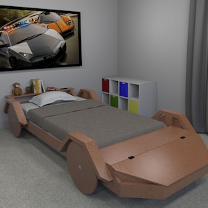 May include: A wooden bed shaped like a sports car with a gray mattress and a teddy bear on the headboard. The bed has a storage compartment and wheels.
