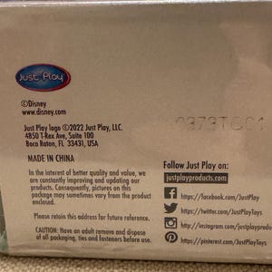 以下が含まれることがあります： Just Playのロゴと「Made in China」の文字が書かれた茶色の段ボール箱。箱には、Just Play, LLC.の連絡先情報と会社のソーシャルメディアへのリンクも記載されています。