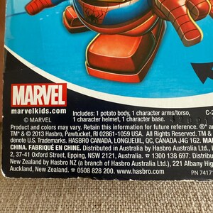 Może przedstawiać: Zabawka Mr. Potato Head z motywem Marvela, inspirowana Spider-Manem. Zabawka ma czerwoną i niebieską kolorystykę, z ż&oacute;łtym hełmem. Opakowanie zawiera logo Marvel i tekst "marvelkids.com". Zawiera korpus, ramiona/tuł&oacute;w, hełm i podstawę.