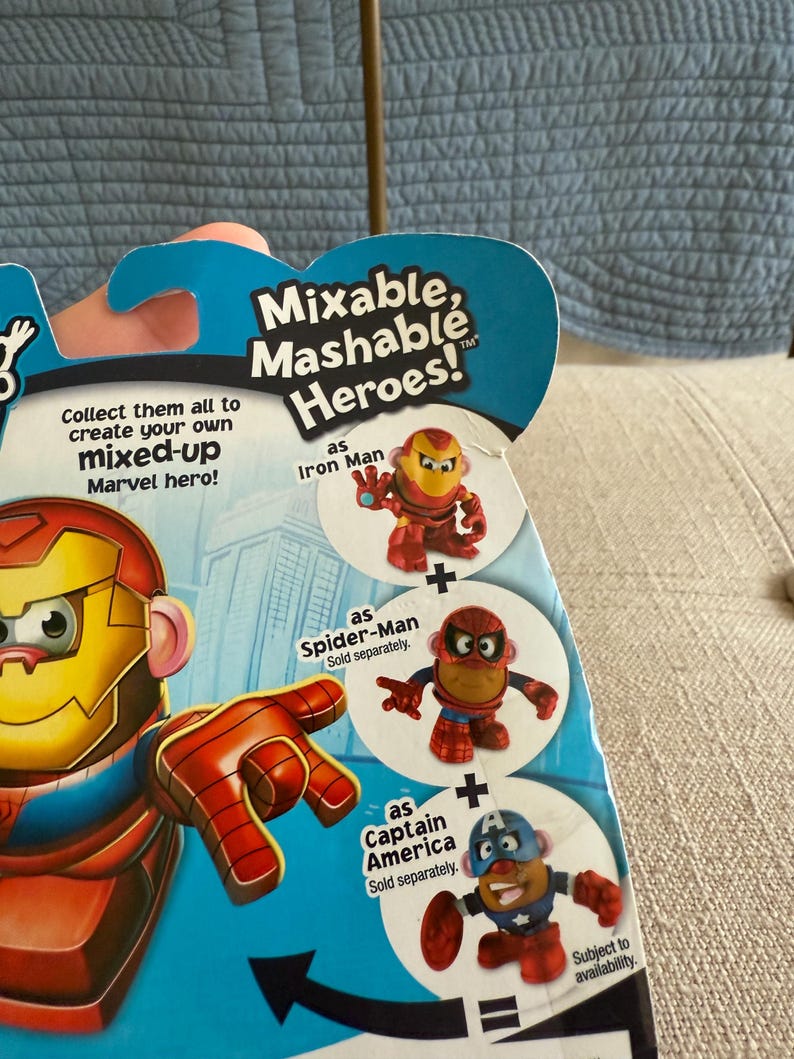 Może przedstawiać: Opakowanie z zabawkami Mixable, Mashable Heroes! z Iron Manem, Spider-Manem i Kapitanem Ameryką. Opakowanie zawiera tekst "Zbierz je wszystkie, aby stworzyć własnego, zmiksowanego bohatera Marvela!" i "W zależności od dostępności."