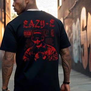 May include: Black t-shirt with a red graphic of Eazy-E, the text "EAZY-E" and "PARENTAL ADVISORY EXPLICIT CONTENT". The shirt also features the NWA logo and a portrait of Eazy-E.