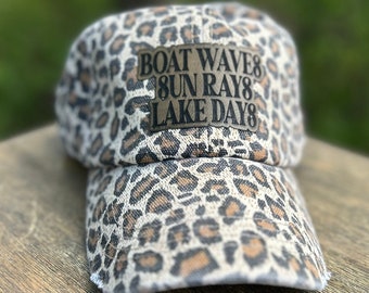 Casquette trucker effet vieillie à imprimé léopard Lake Days avec écusson gravé en similicuir. Bonnet effet vieilli Lake Days, vagues de bateau, rayons du soleil.