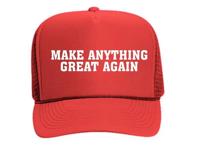 Puede incluir: Gorra de camionero roja con texto blanco "MAKE ANYTHING GREAT AGAIN". La gorra tiene una parte trasera de malla y una visera curva. El texto est&aacute; en negrita, sin serifa.