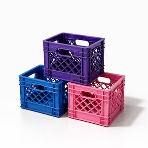 May include: A stack of three rectangular plastic storage crates featuring a diamond-patterned lattice design on the sides and integrated handles. The top crate is purple, while the two bottom crates are blue and pink, respectively.