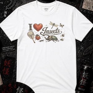 Könnte beinhalten: Ein weißes Kurzarm-T-Shirt mit einem Grafikdruck, der I heart Insects zeigt. Das Design umfasst ein rotes Herz, einen Schmetterlingskescher, einen Marienkäfer, eine Libelle, einen Käfer, eine Biene und einen kleinen Schmetterling in Farben.
