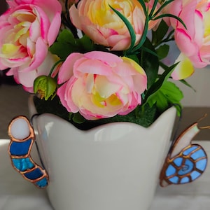 Handgjorda hängande blomkrukor av målat glas med mask och snigel