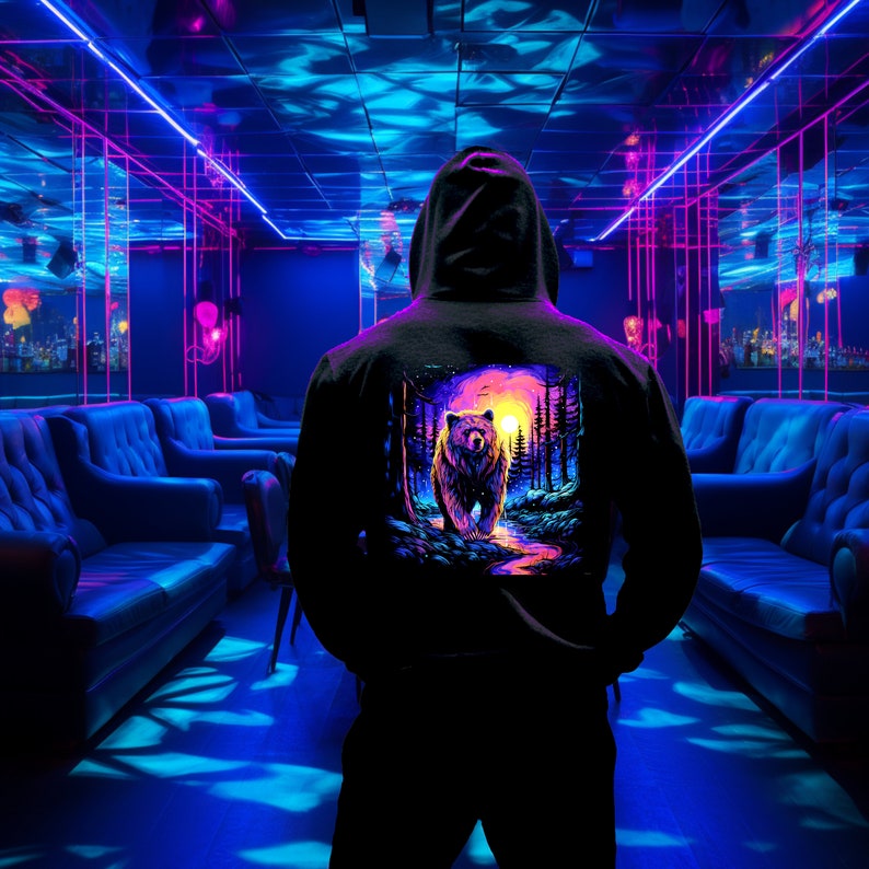 May include: A black hoodie with a colorful graphic print of a bear standing in a forest with a sunset in the background.